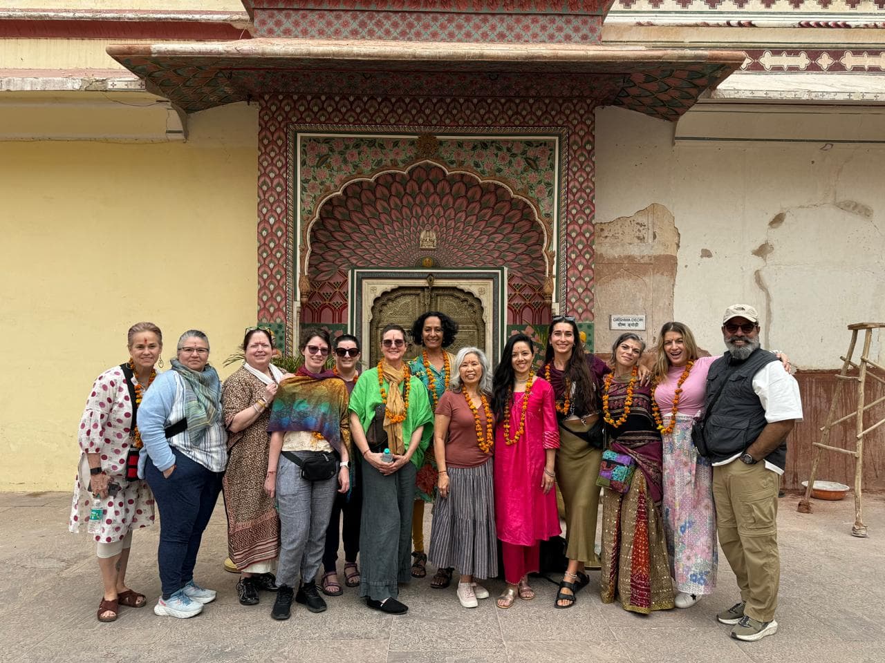 Guests garlanded with marigolds at an ornate palace gateway