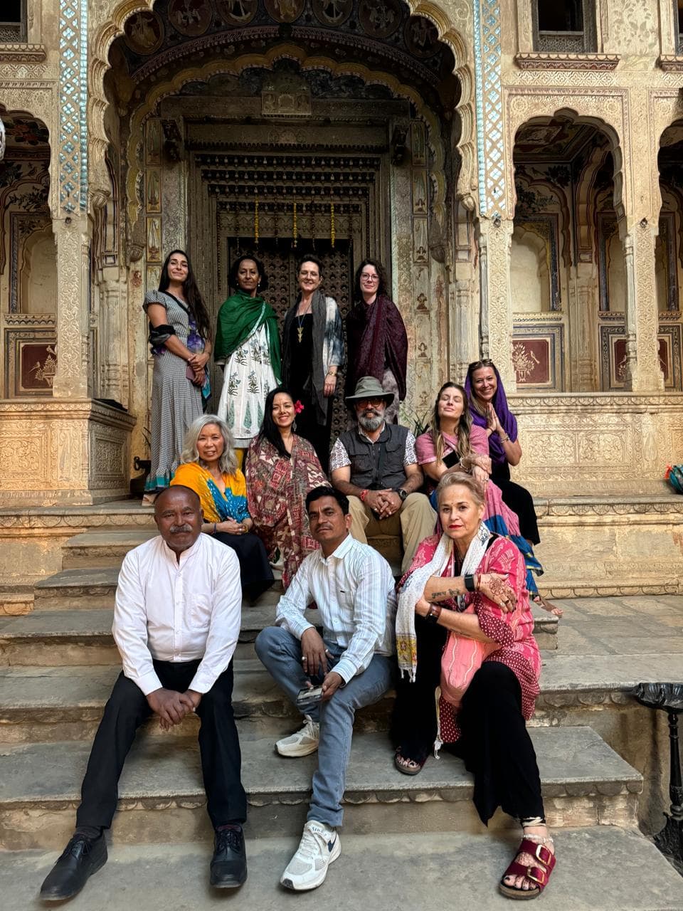 Rajiv Tomar with guests on the steps of a painted heritage haveli